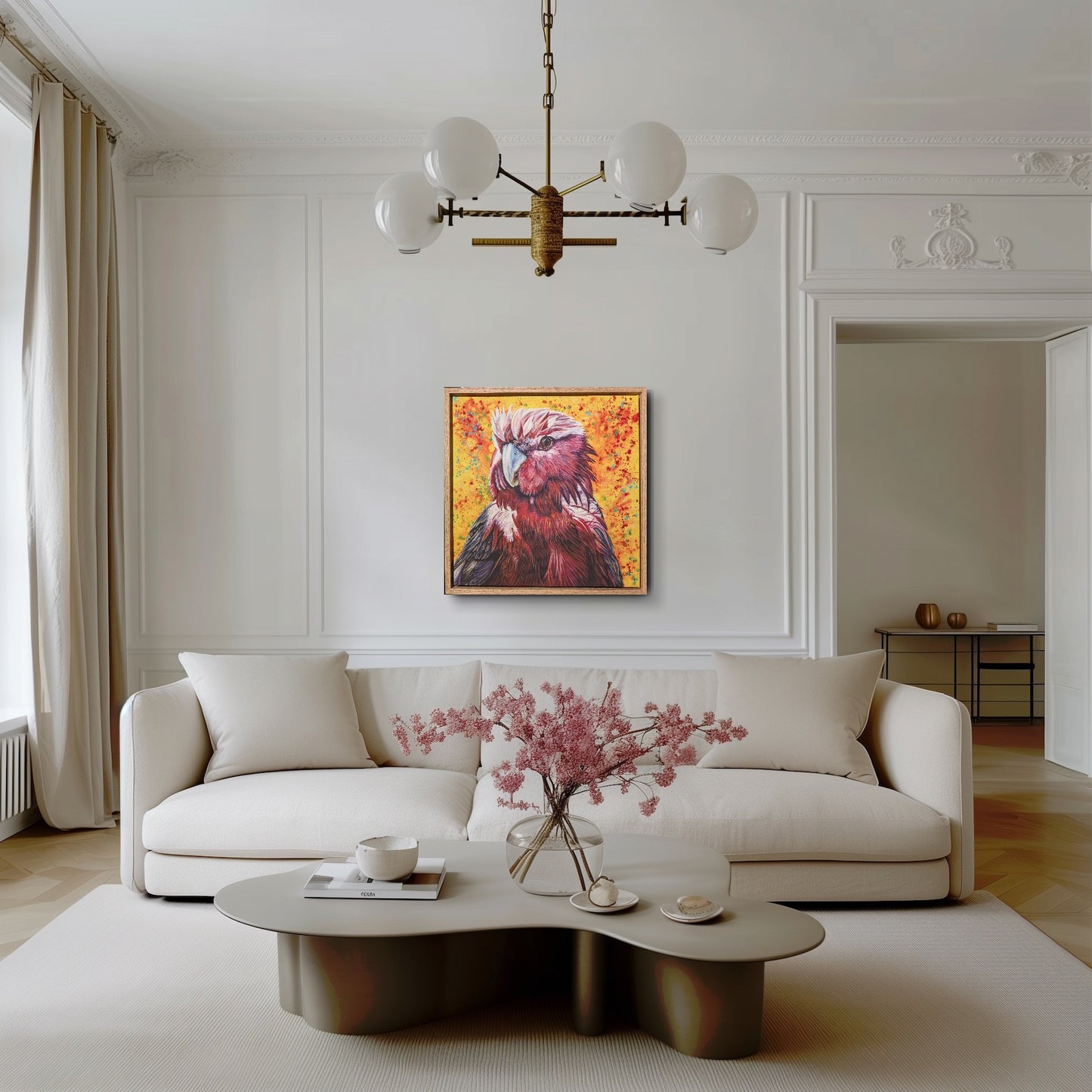 Modern living room with a white sofa, coffee table, and framed fine art print of Wally the Galah by Kelly Batsiokis on the wall to show scale.