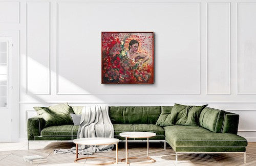 Green sofa in a living room with a colorful abstract painting on the wall.