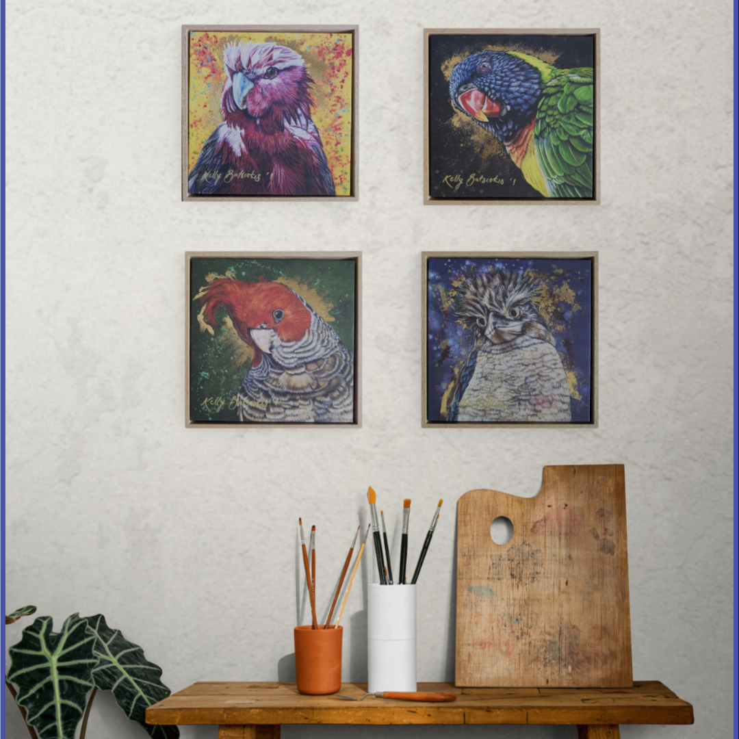 Four framed embellished fine art print parrot artworks on a wall above a wooden bench with art supplies to show how the four embellished prints could look if all purchased.